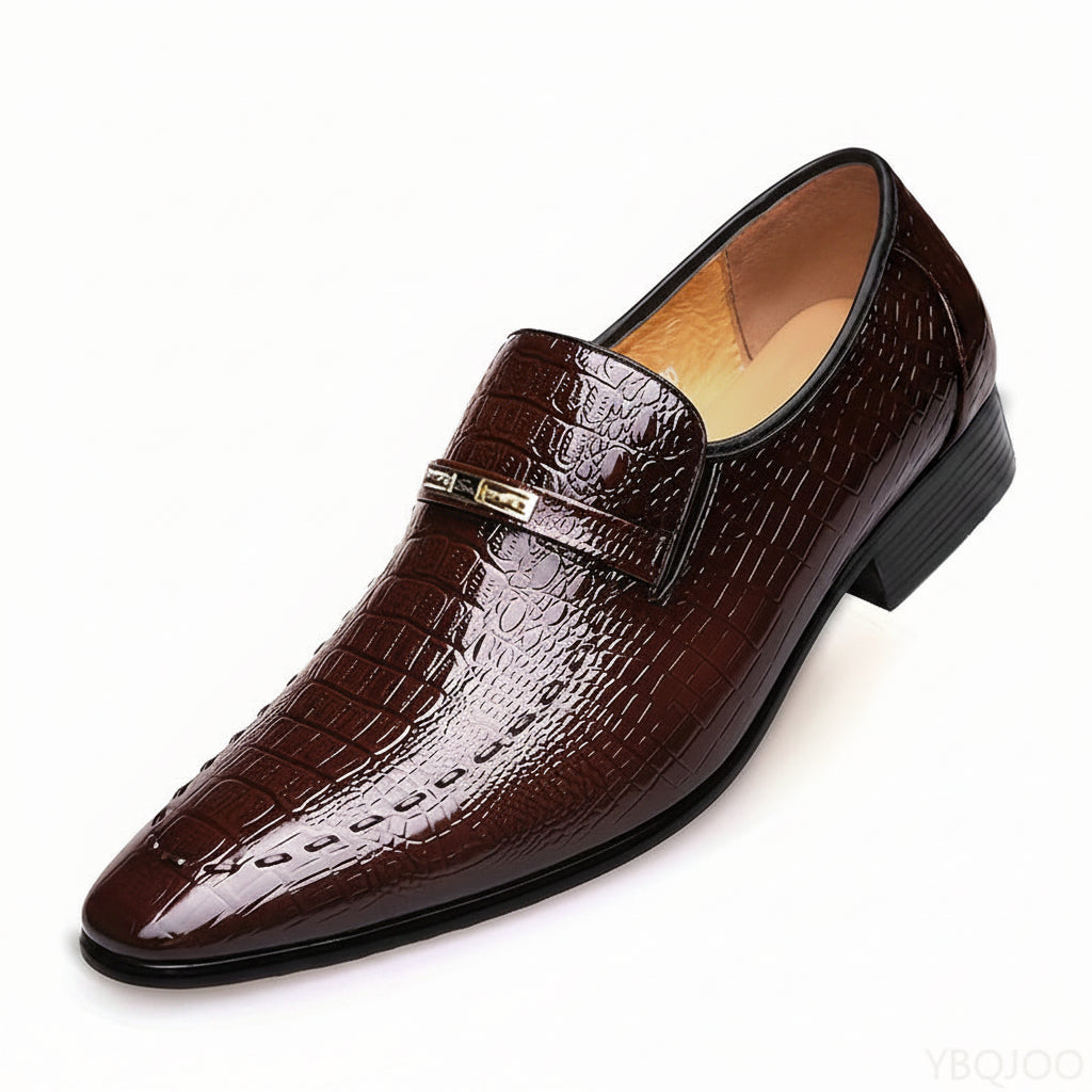 Brown crocodile-patterned loafer shoe on a white background
