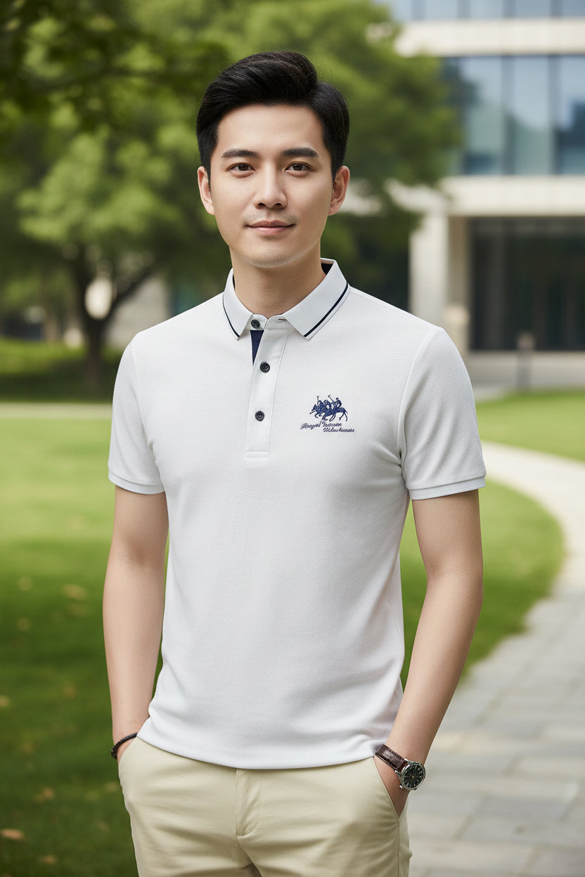Man wearing a white polo shirt with a logo on a dark background