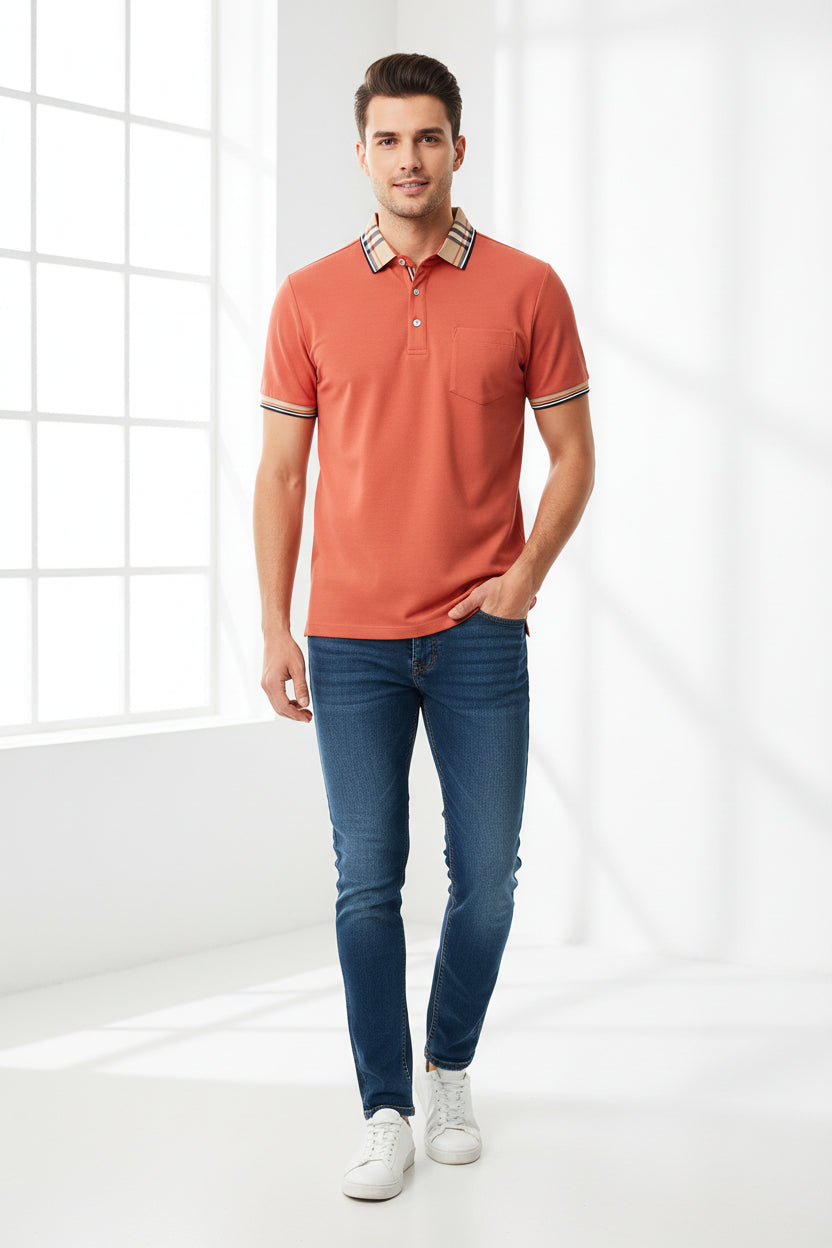 Orange polo shirt with plaid collar held by a hand, brand label visible