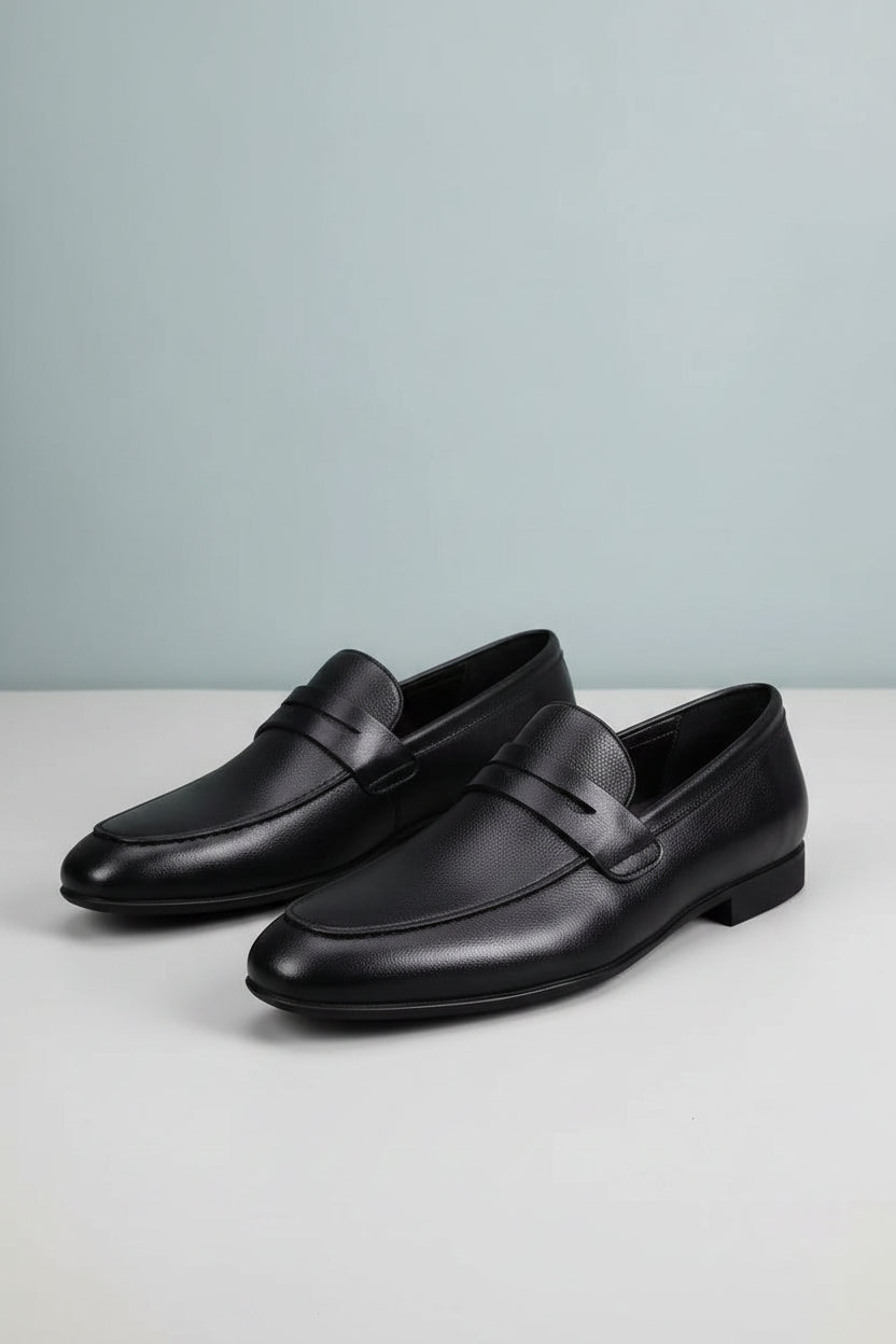 Black leather loafers on white blocks with text about comfort and style.
