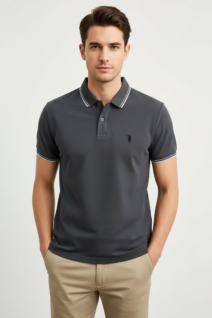 Dark gray polo shirt with white trim held by a hand against a neutral background