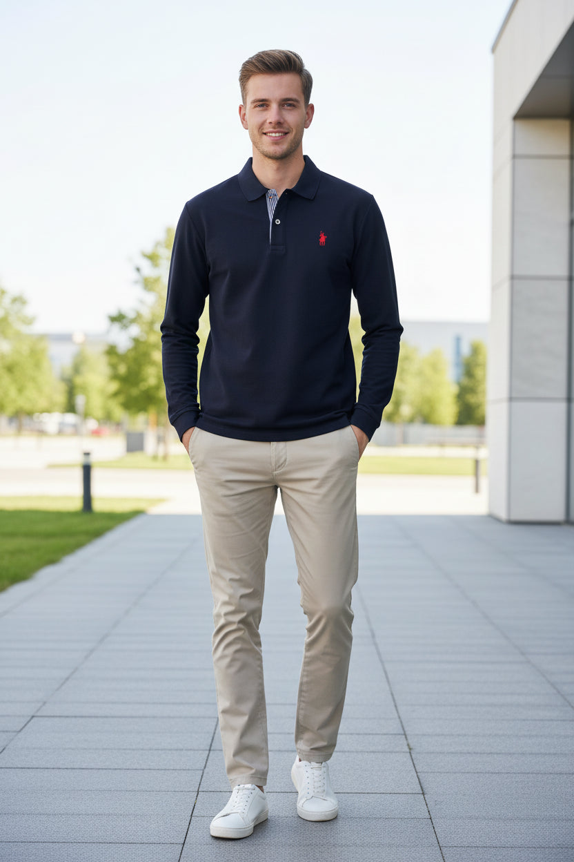 Navy blue polo shirt with red logo held by a hand, with more shirts in the background.