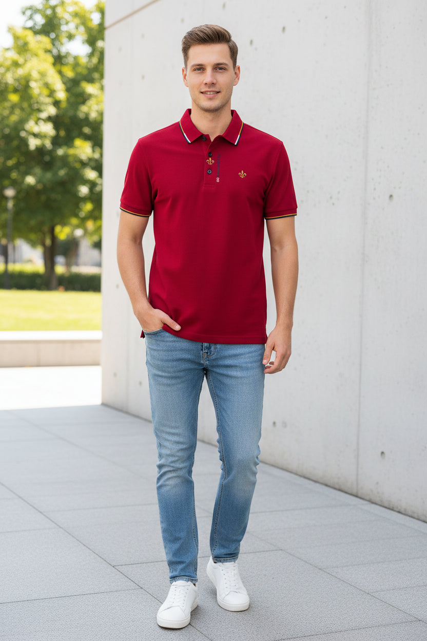 Red polo shirt with a brand logo held by a hand against a blurred clothing store background.