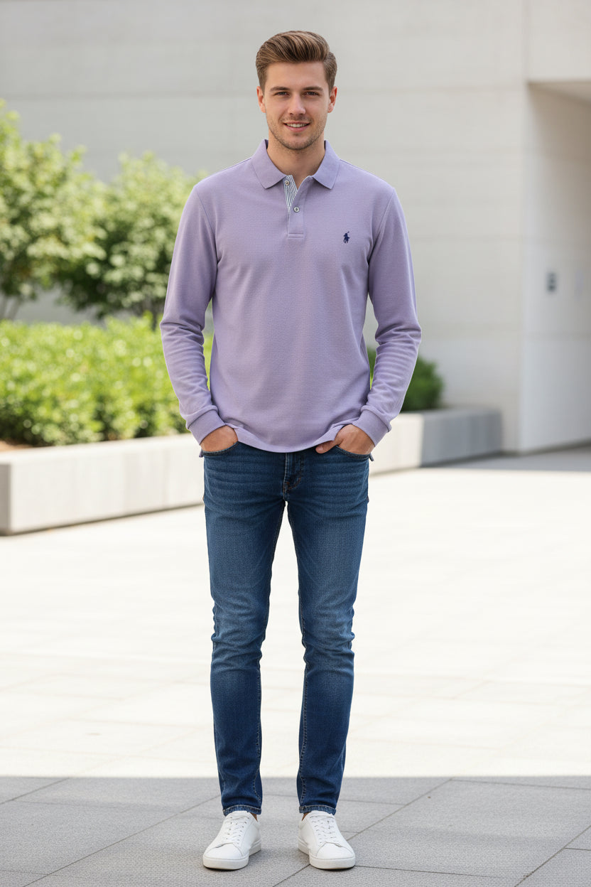Purple polo shirt with a brand logo held by a hand on a rack of shirts.