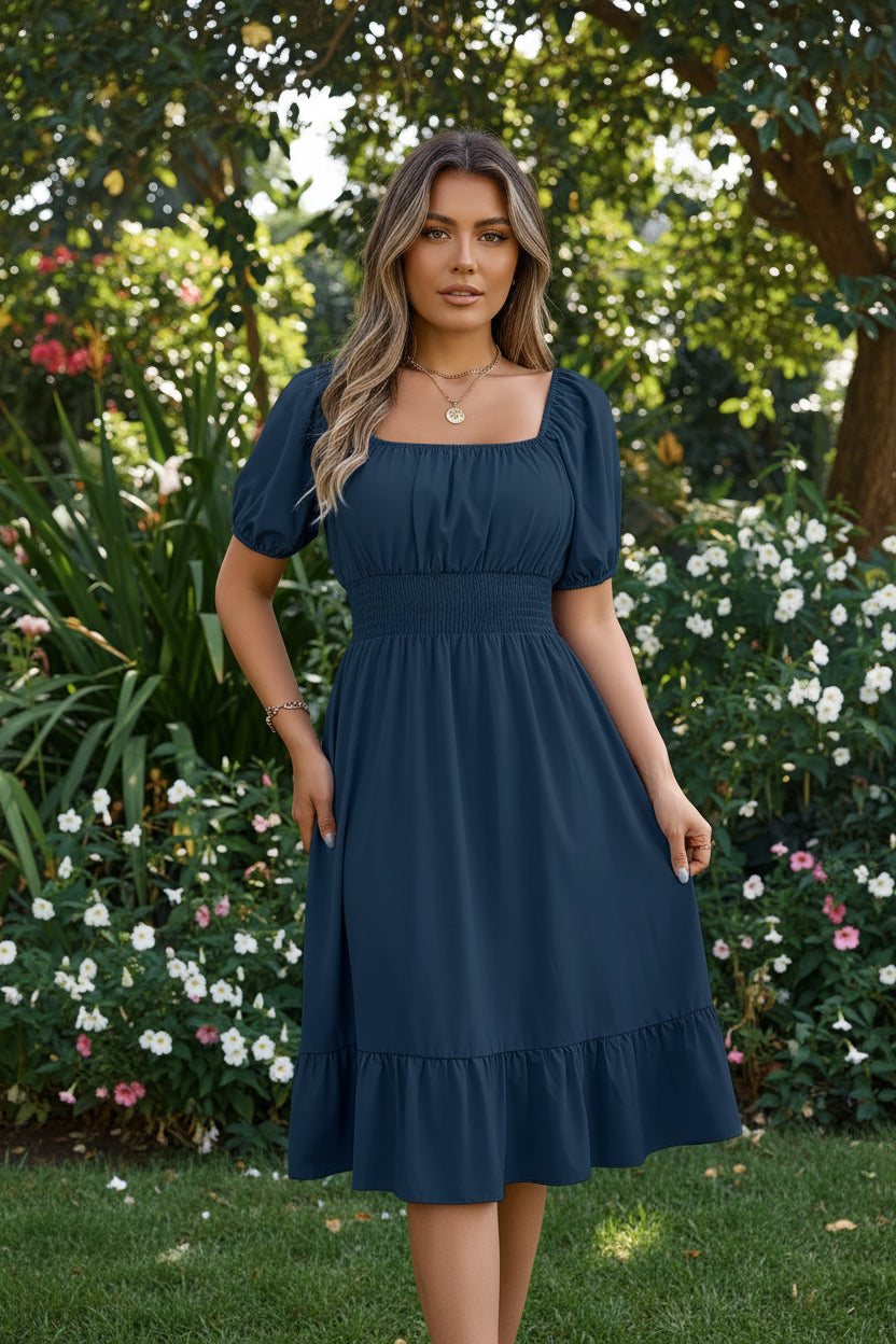 Woman wearing a navy blue dress with puff sleeves in a room setting.