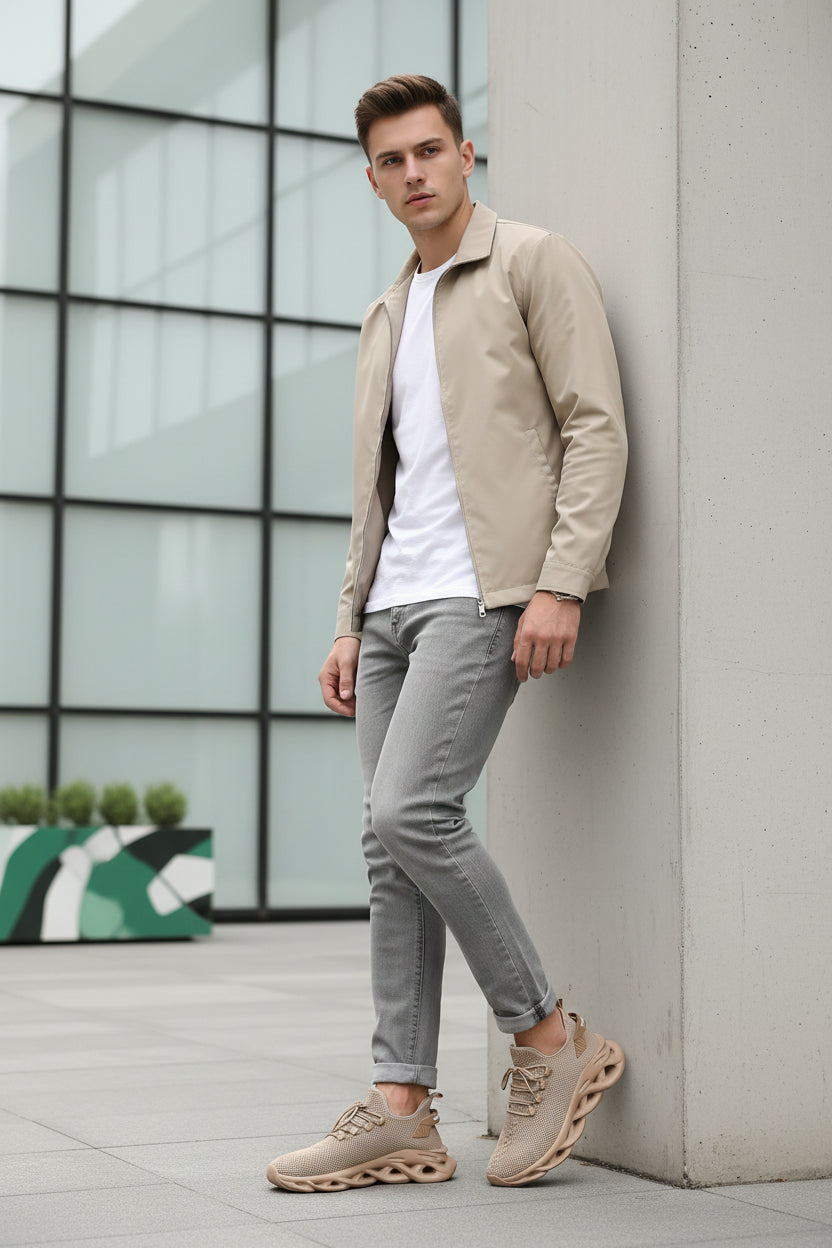 Beige running shoes with a brand logo on a a young man wearing it ouside