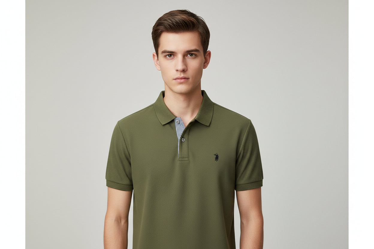 Green polo shirt with a brand logo on a hanger, held by a hand.