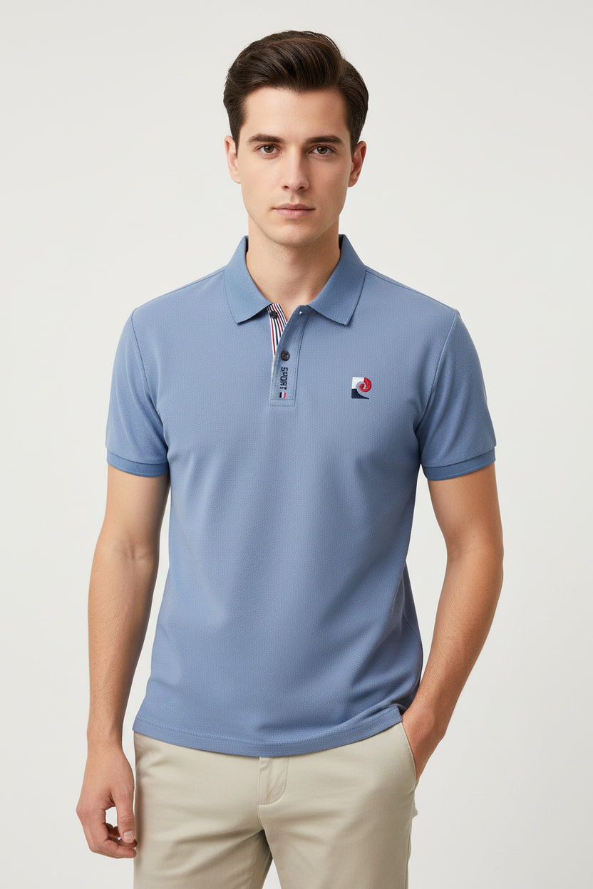 Blue polo shirt with brand logo held by a hand in a clothing store setting.