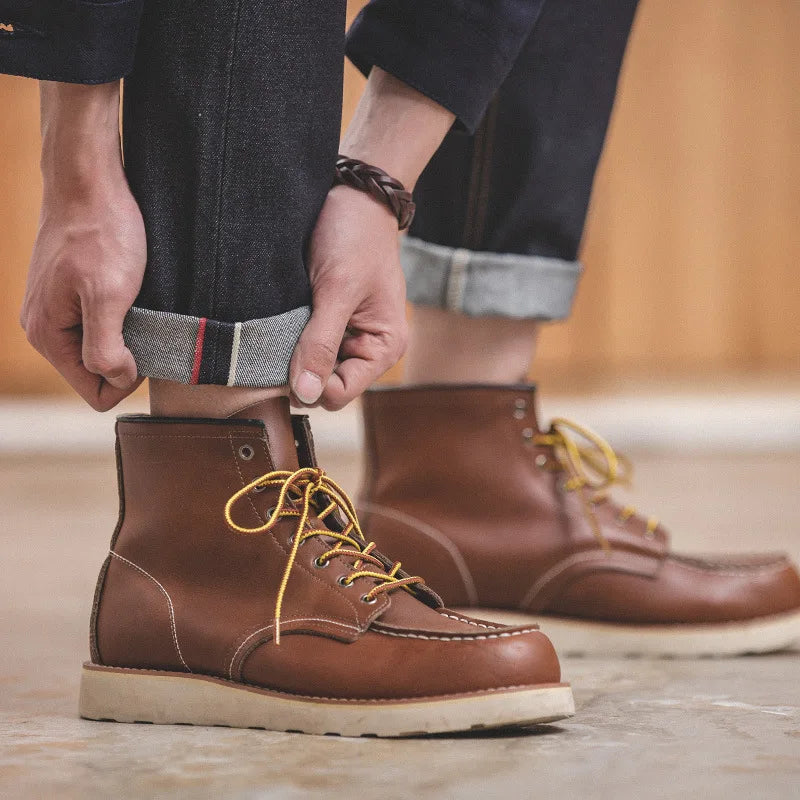 Person adjusting a brown leather boot with yellow laces on a blurred background