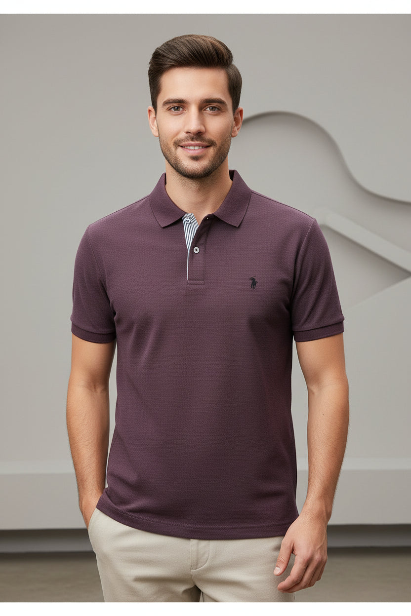 Purple polo shirt with a brand logo held by a hand on a hanger.