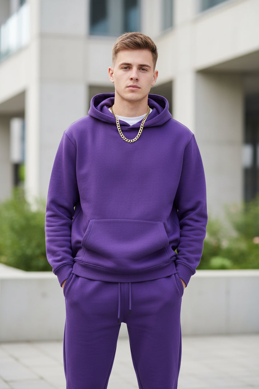 Person wearing a purple hoodie and pants set on a white background
