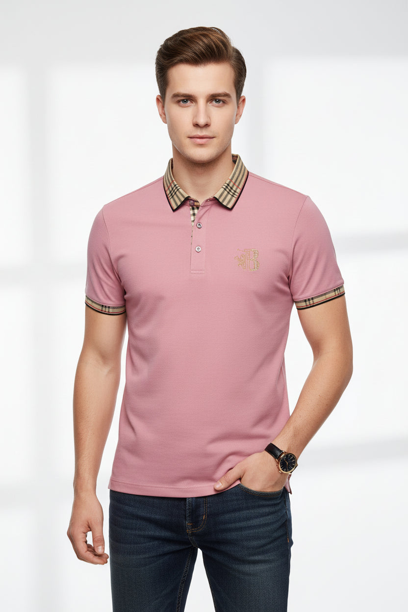 Pink polo shirt with checkered collar and brand logo, accompanied by a watch on a gray surface.