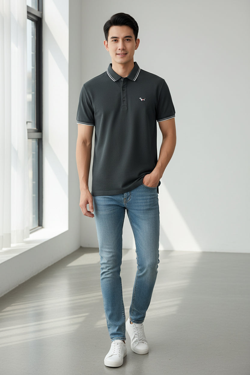 Gray polo shirt with white trim held by a hand, brand logo visible