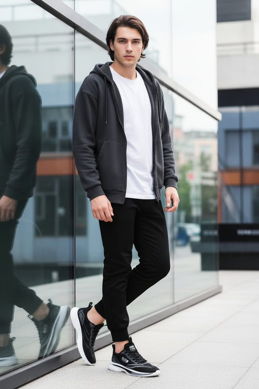 Black running shoes with white soles worn by a person, blurred background
