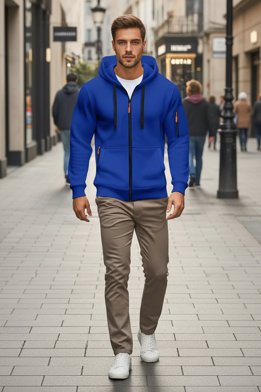 Man wearing a blue hoodie with orange accents on a city street.