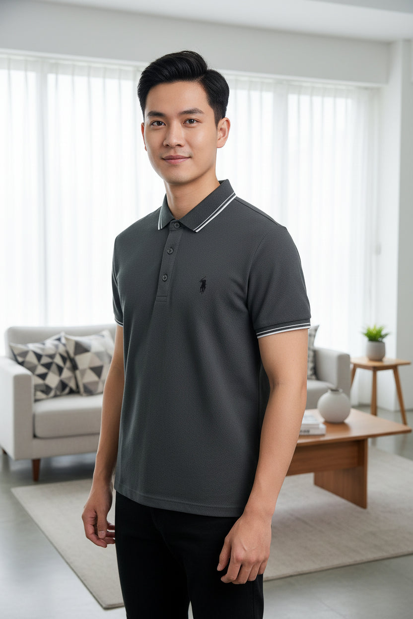 Dark gray polo shirt with white trim on a hanger, held by a hand.