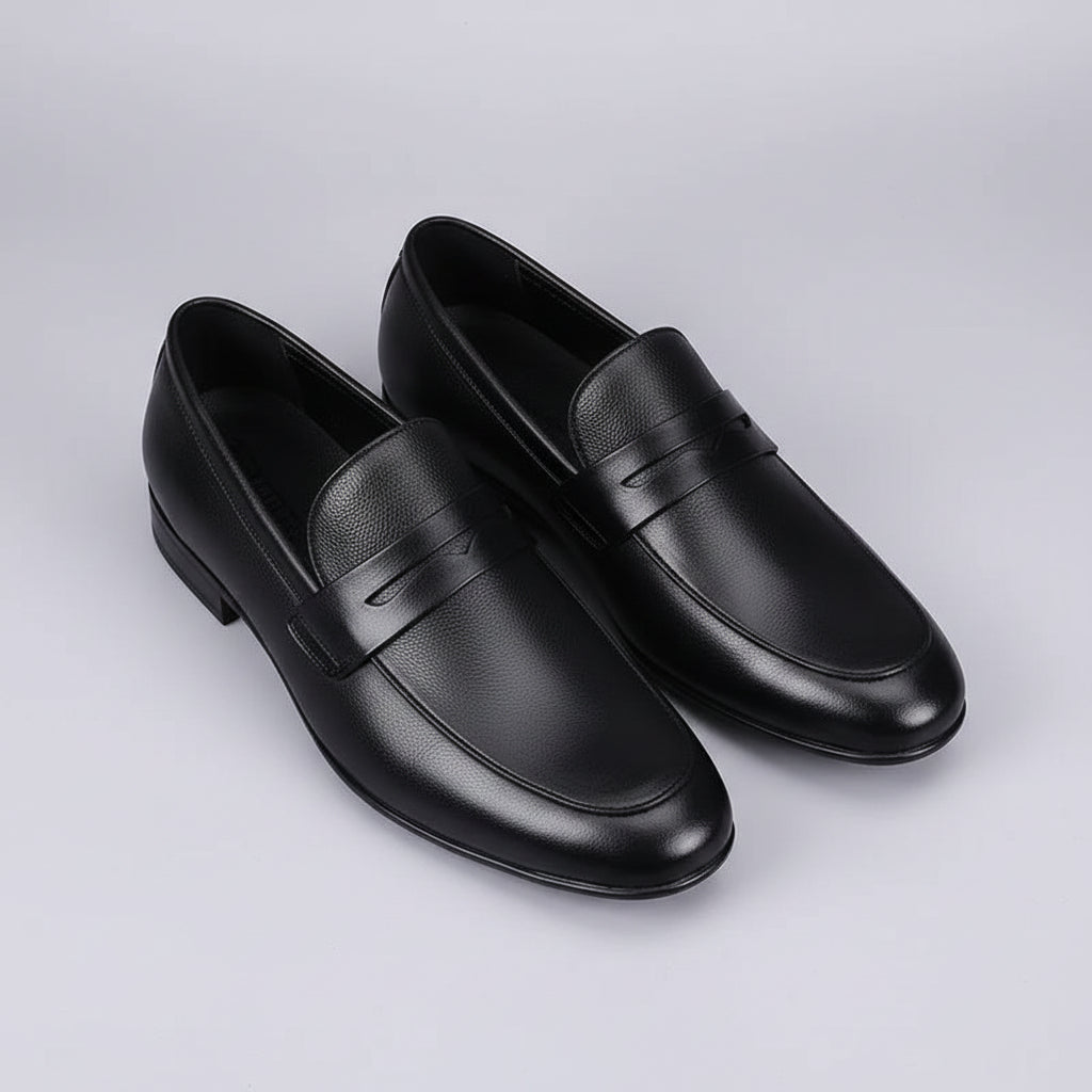 Pair of black leather shoes on a gray textured background