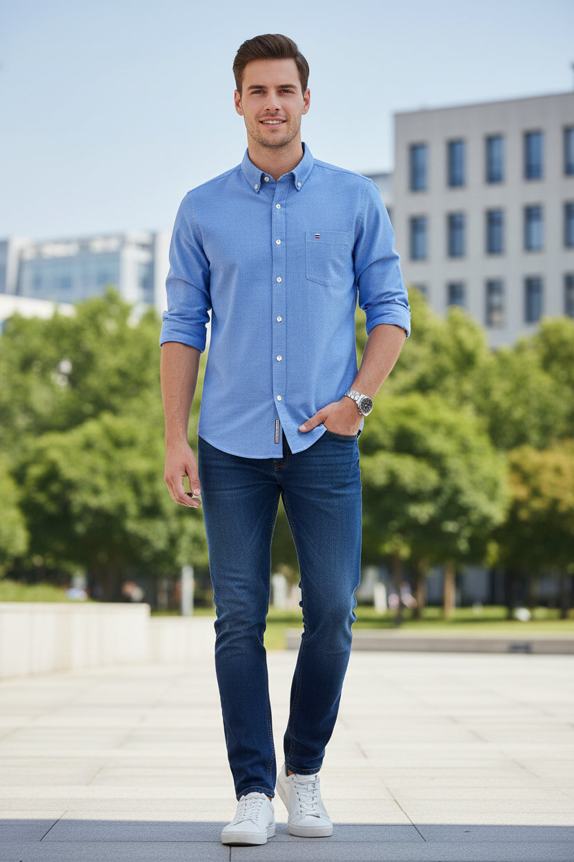 Folded blue shirt with brand logo on a light gray background