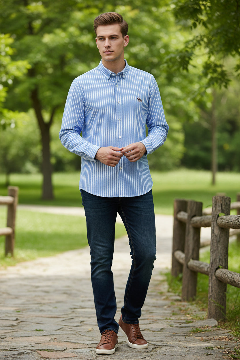 Folded blue and white striped shirt with a logo on a gray surface