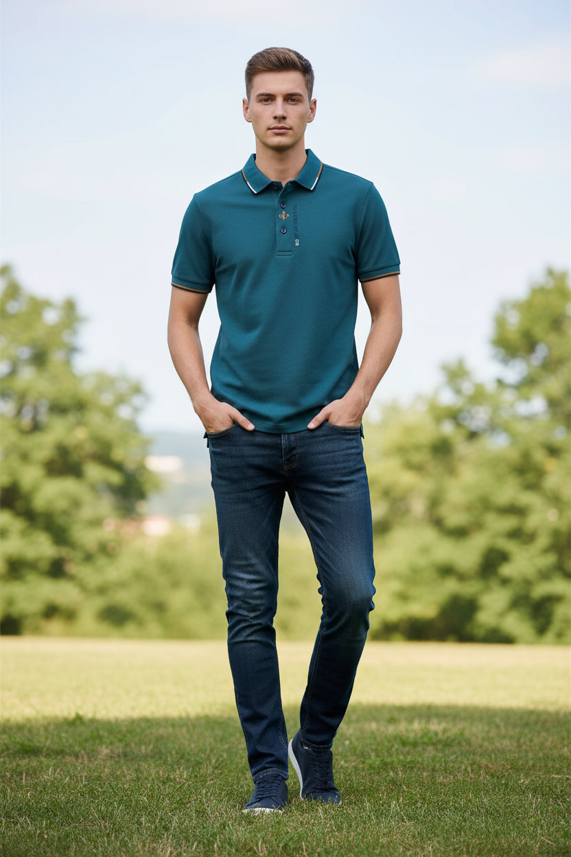 Green polo shirt with brand logo held by a hand on a gray background