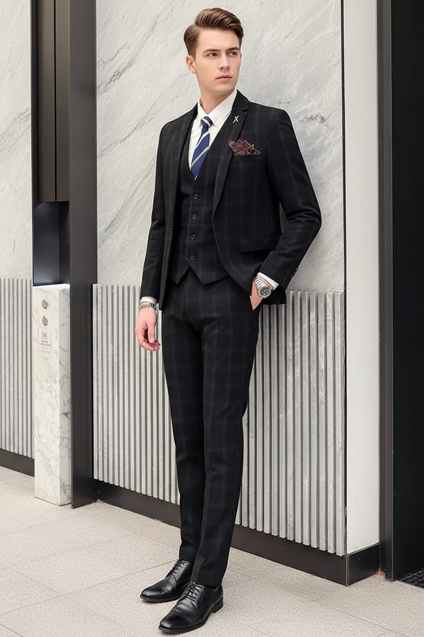 Man wearing a dark pinstripe suit with a white shirt and blue tie, standing against a marble wall.