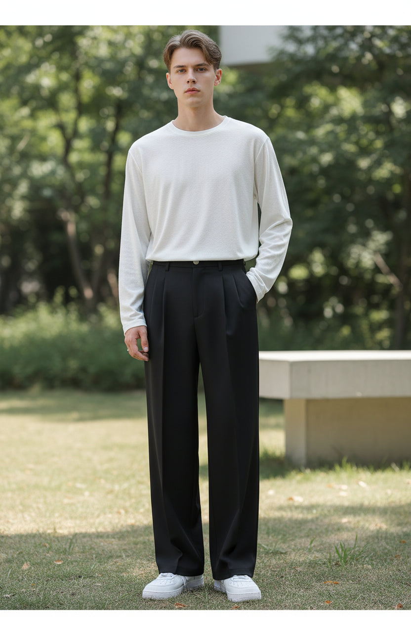 Person wearing black wide-leg pants and white shoes against a plain background