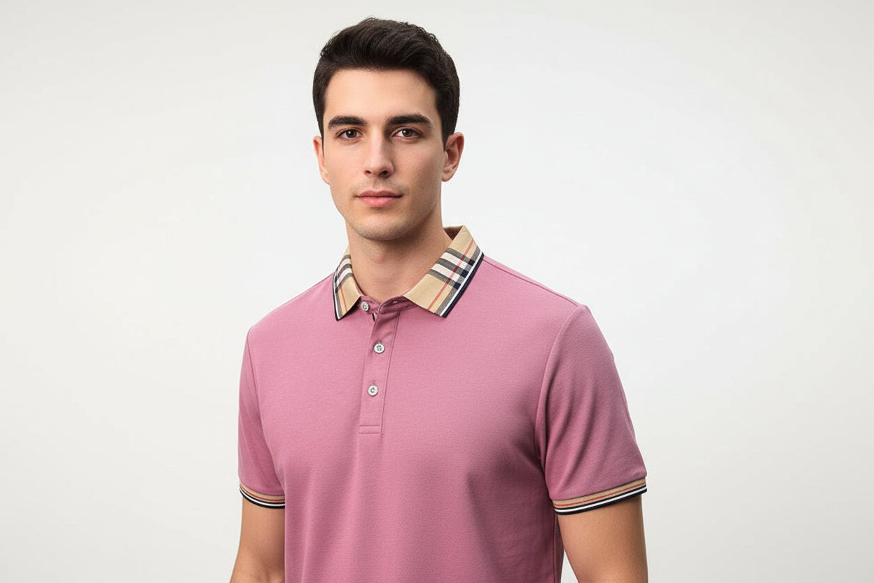 Pink polo shirt with plaid collar held by a hand, brand label visible