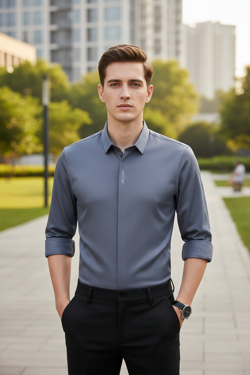 Blue dress shirt with rolled-up sleeves worn by a person on a gray background