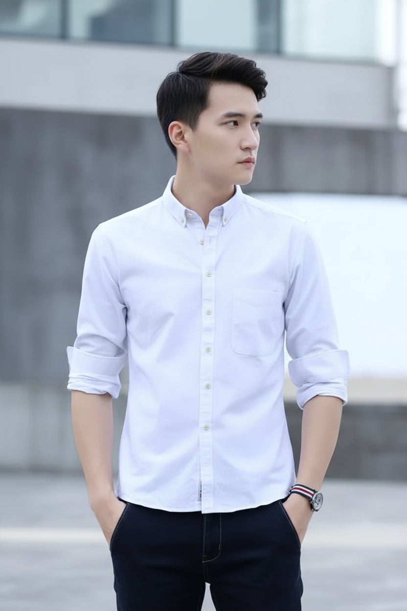 Person wearing a light blue button-up shirt with rolled-up sleeves against a blurred background