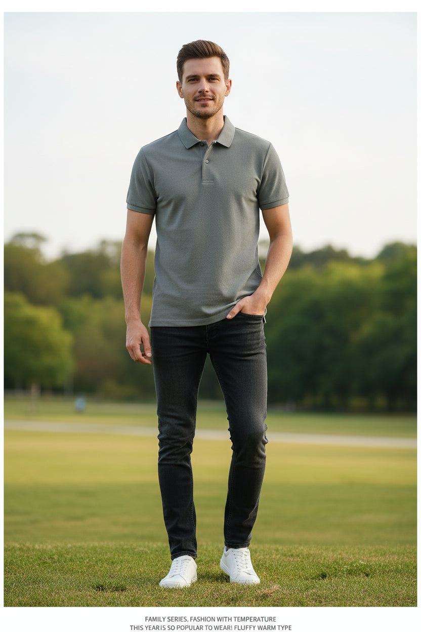 Gray polo shirt held by a hand with other shirts in the background