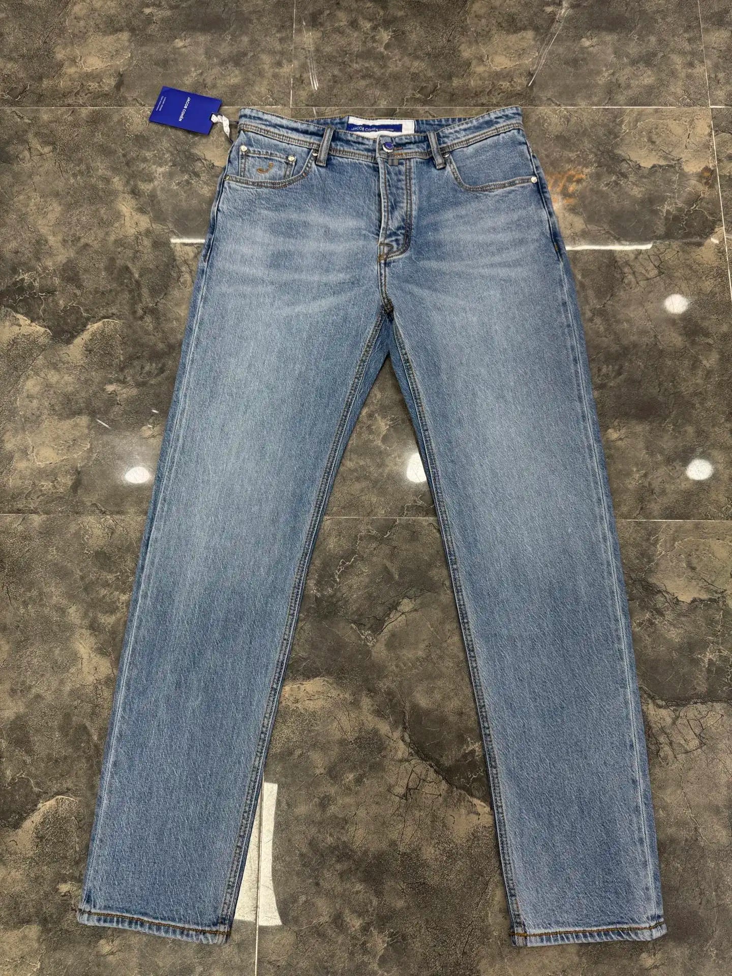 Pair of blue jeans on a textured gray floor