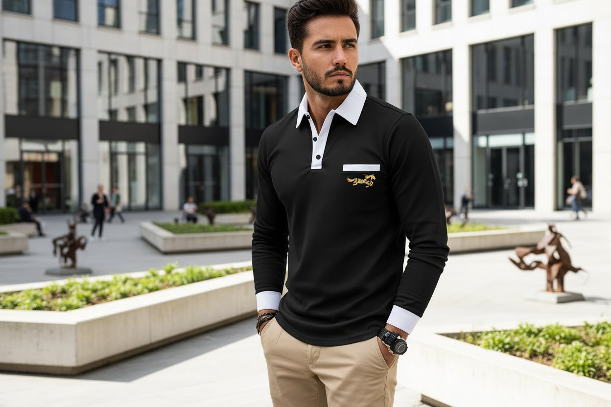 Man wearing a black long-sleeve polo shirt with a logo, standing against a reflective surface.