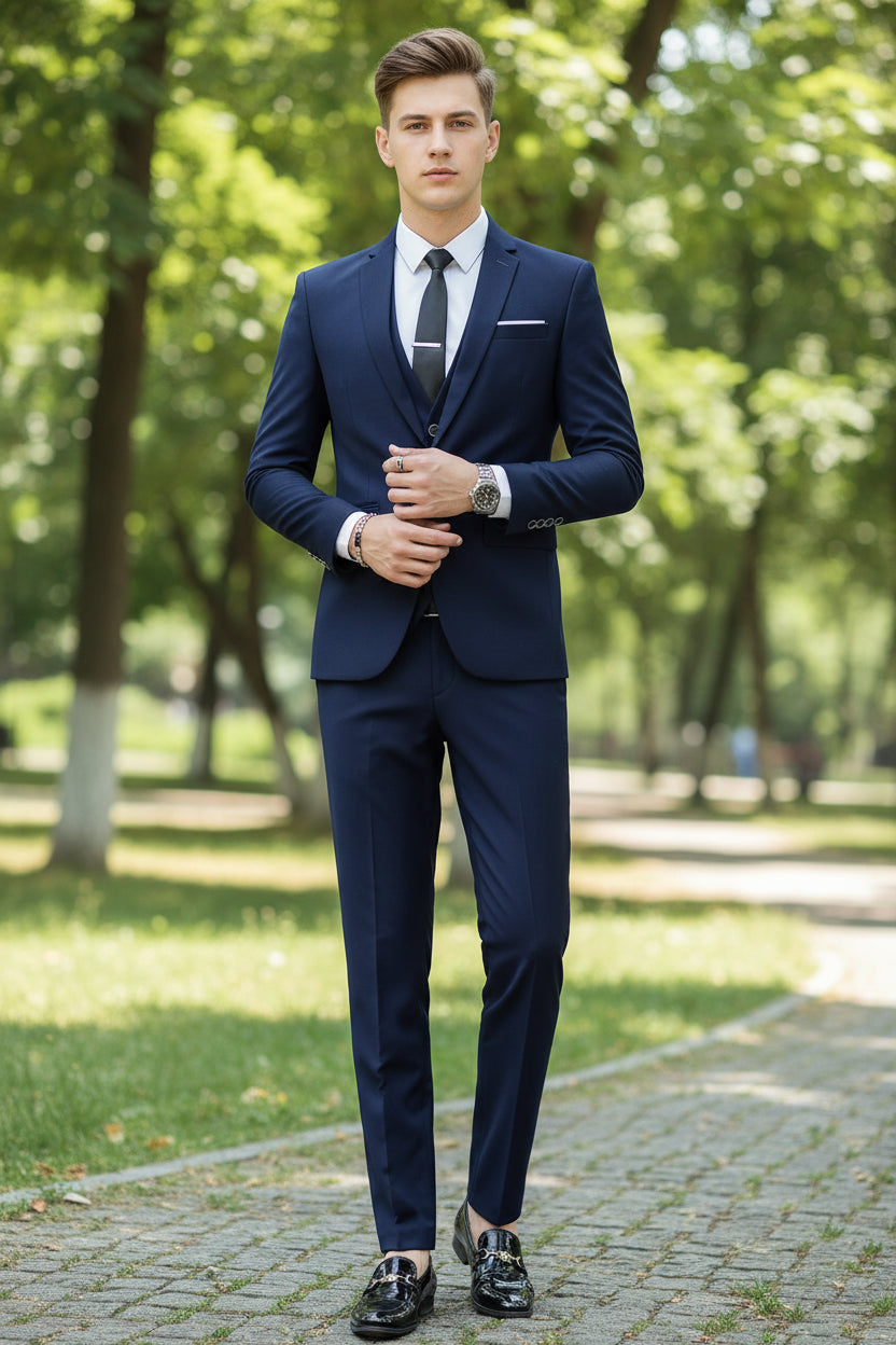 Man in a blue suit standing in an urban setting with a concrete wall and floor.