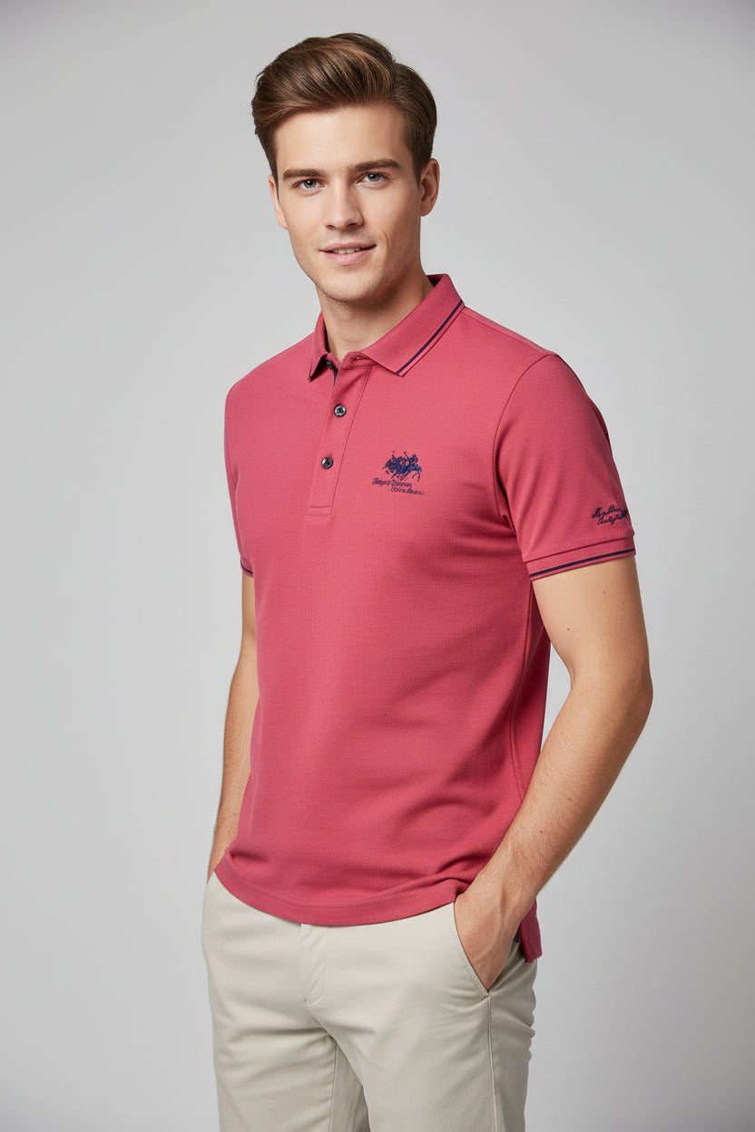 Folded red polo shirt with brand logo on a dark surface