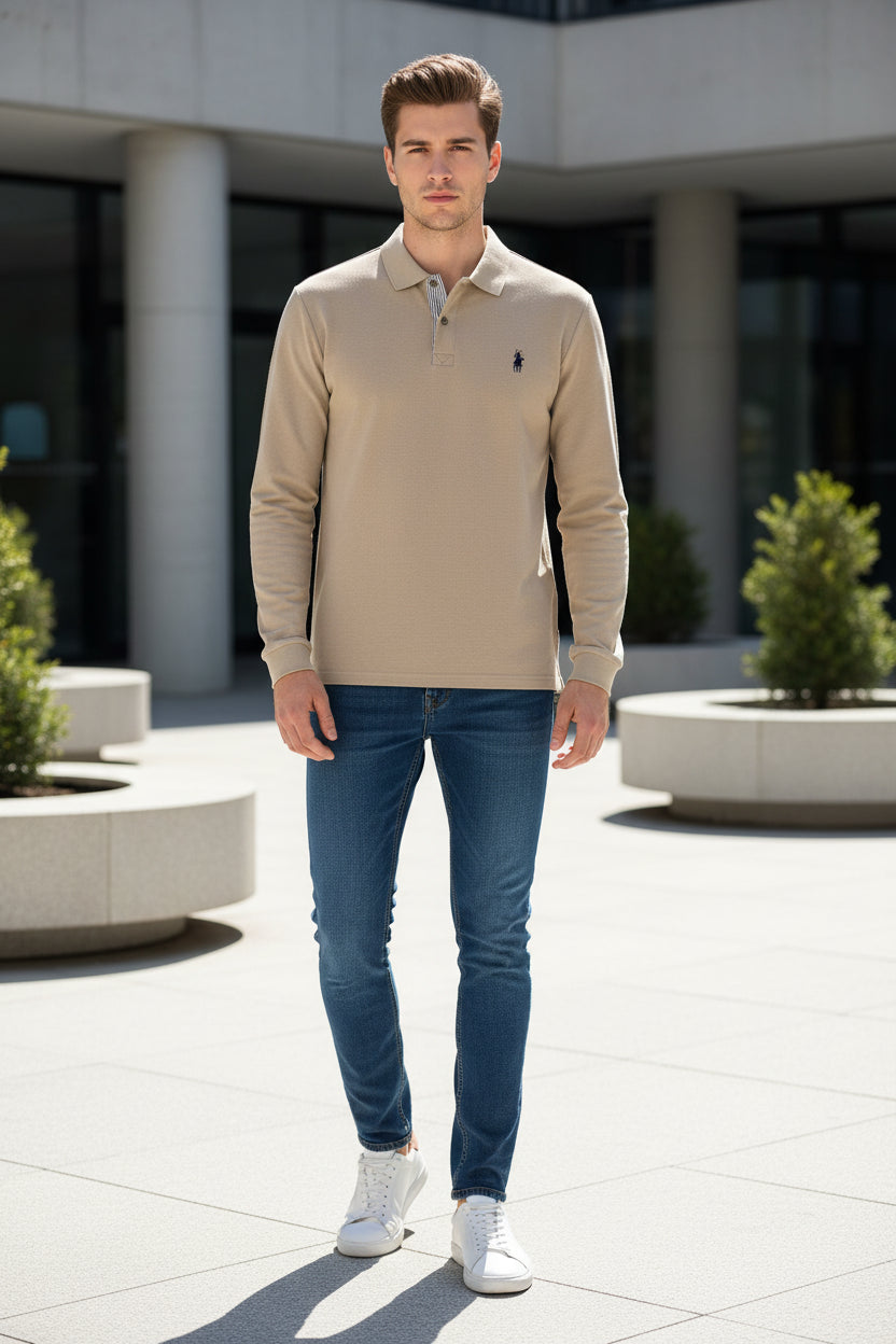 Beige long-sleeve polo shirt with a brand logo on a hanger against a clothing rack background.