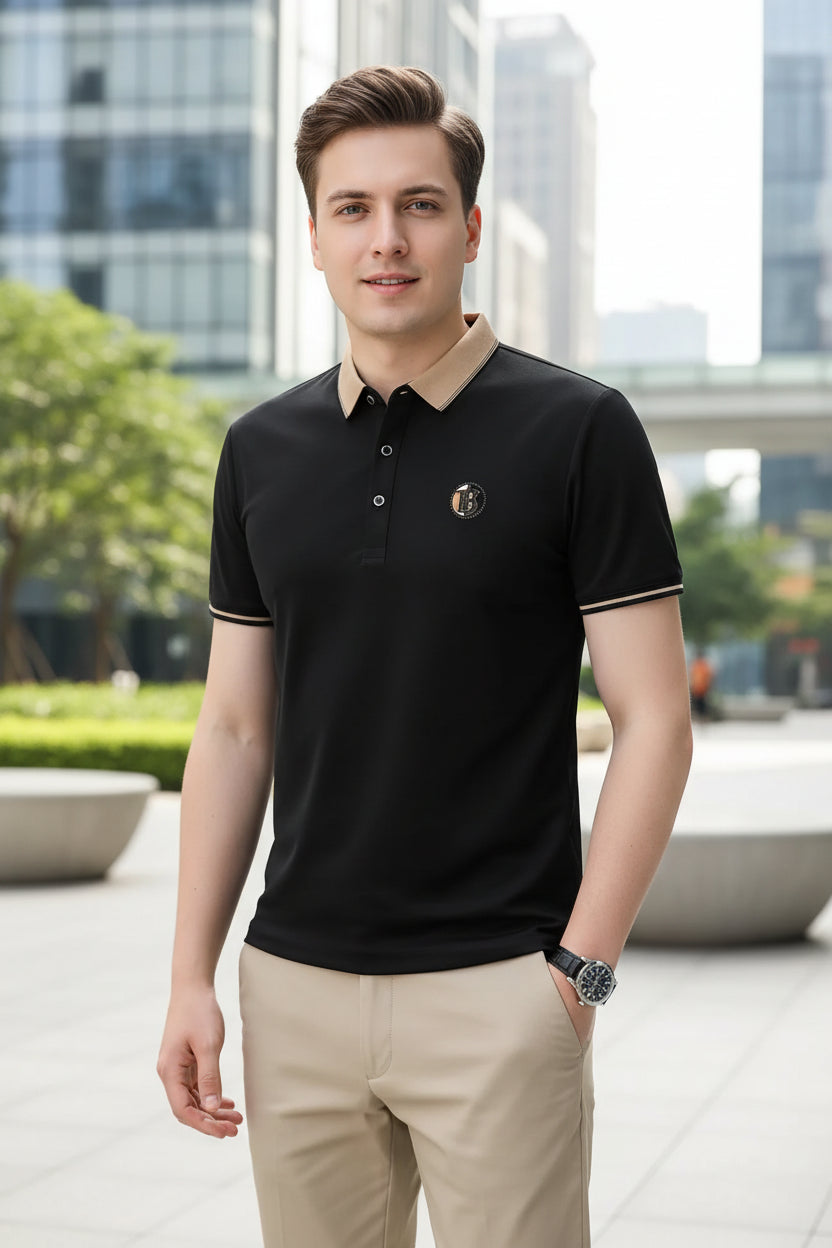 Black polo shirt with a small logo on a gray background