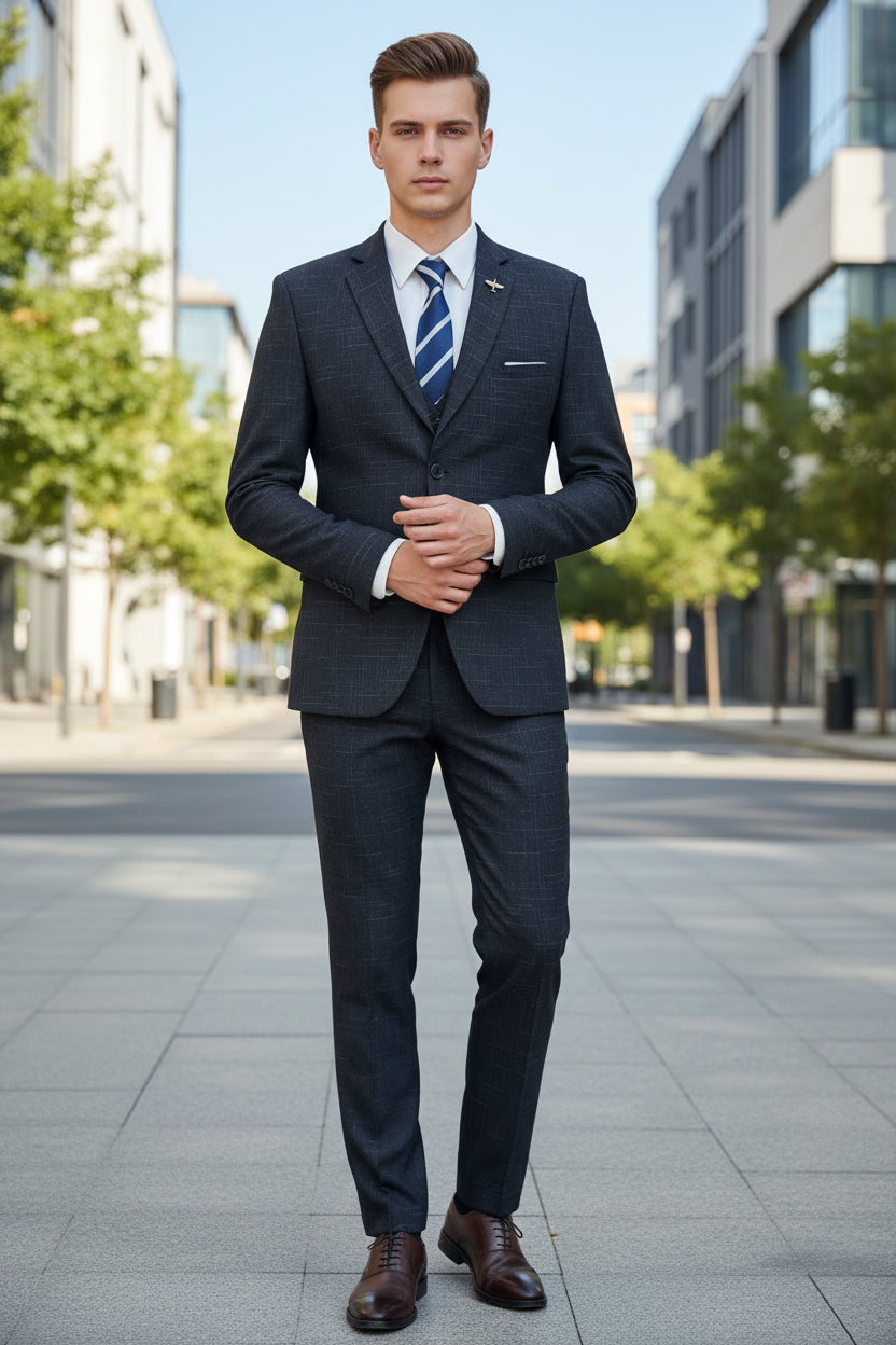 Gray checkered suit with a decorative lapel pin and striped tie against a blurred background