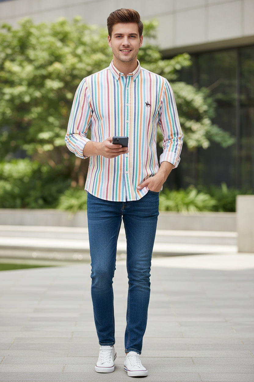 Folded multicolored striped shirt with a logo on a gray textured surface
