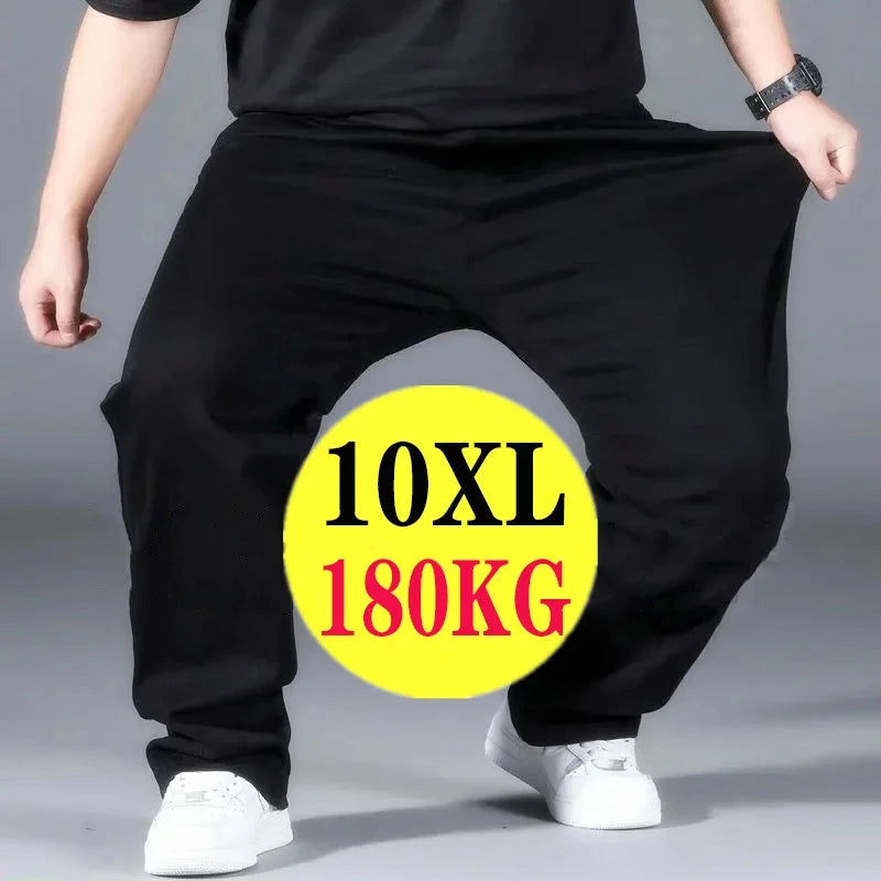 Person wearing a large black 10XL pants with a yellow label indicating weight capacity on a gray background