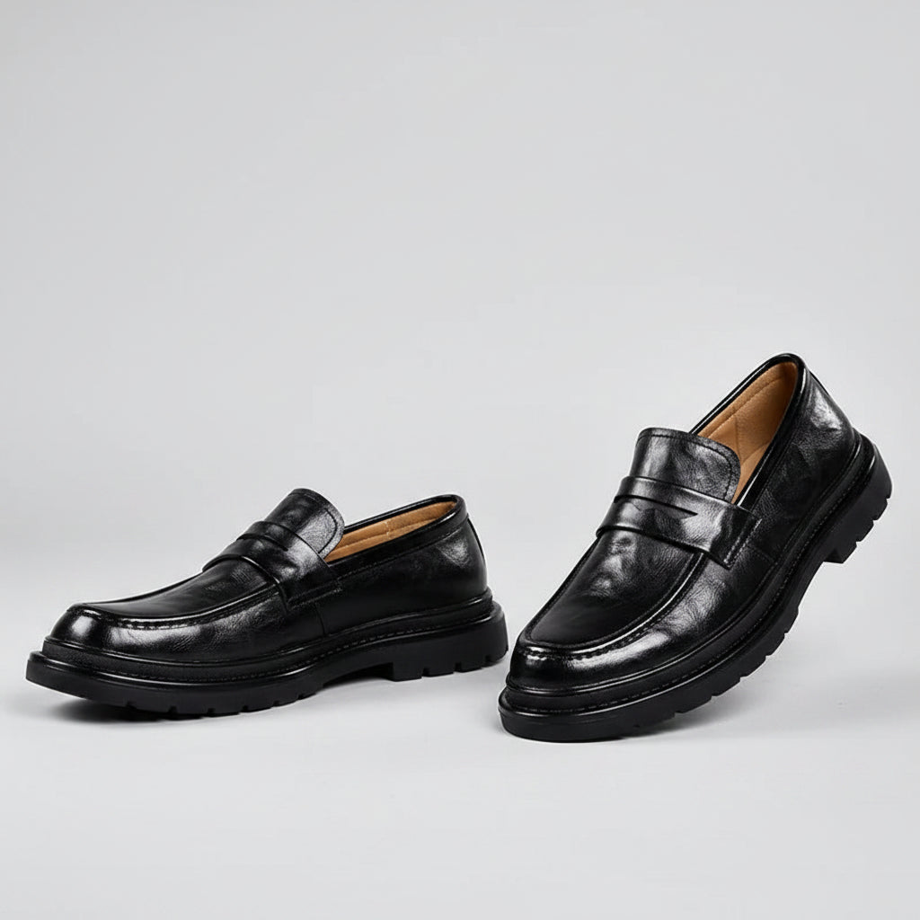 Black leather shoes worn with black pants on a beige background