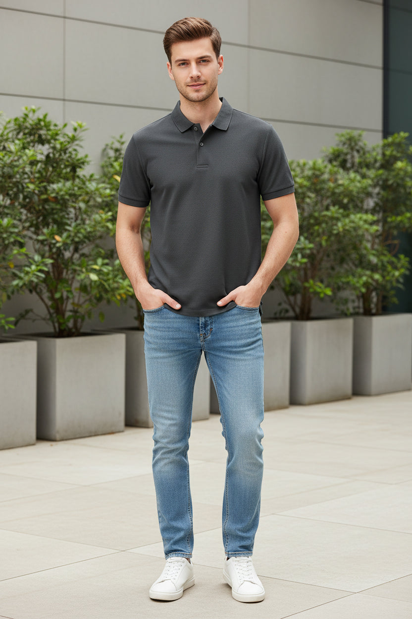 Gray polo shirt on a rack with a hand touching it