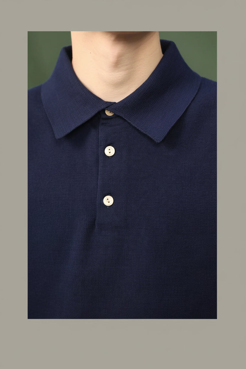 Navy blue polo shirt with three buttons on a plain background