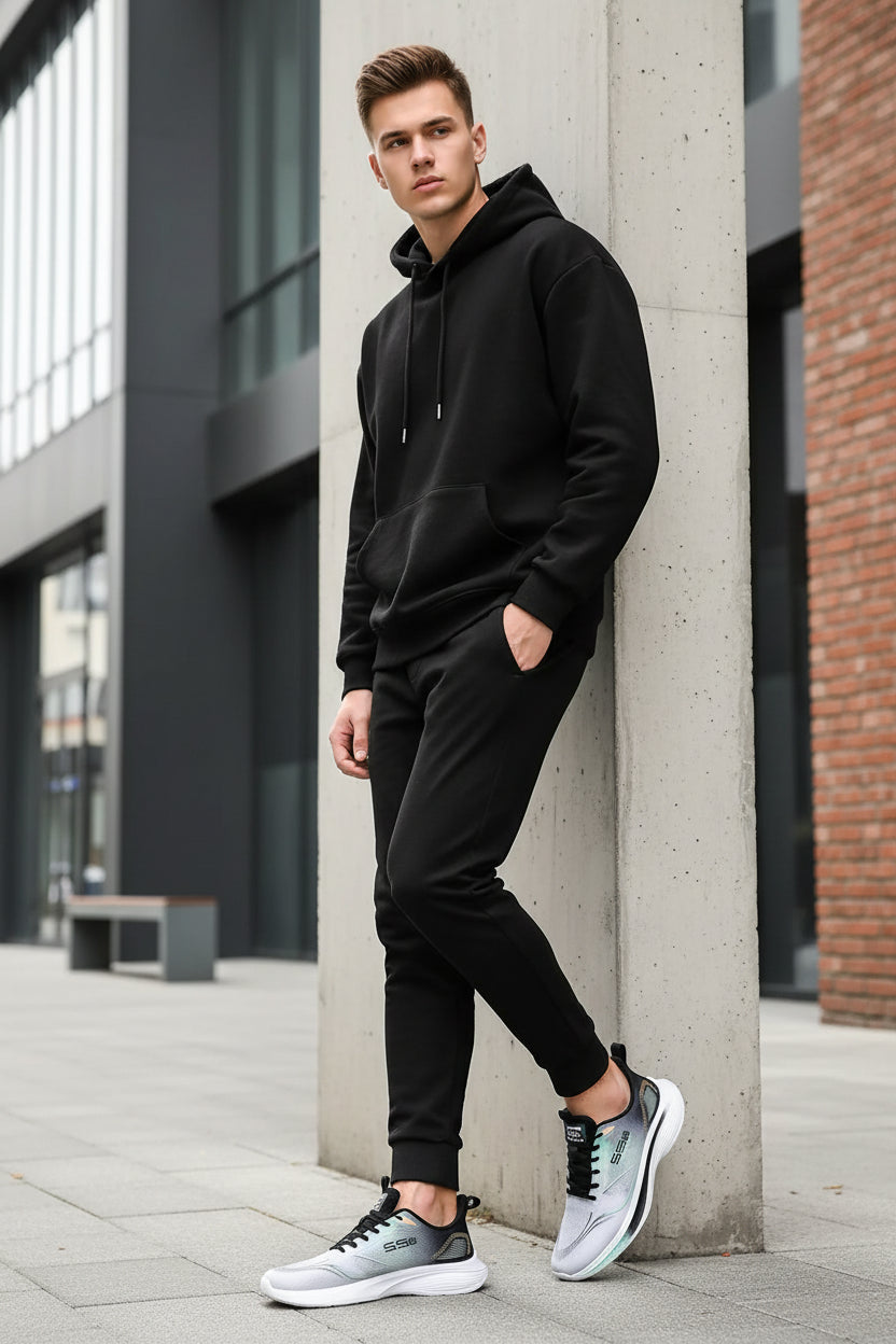 Gray and black athletic shoe with white sole on a gray background
