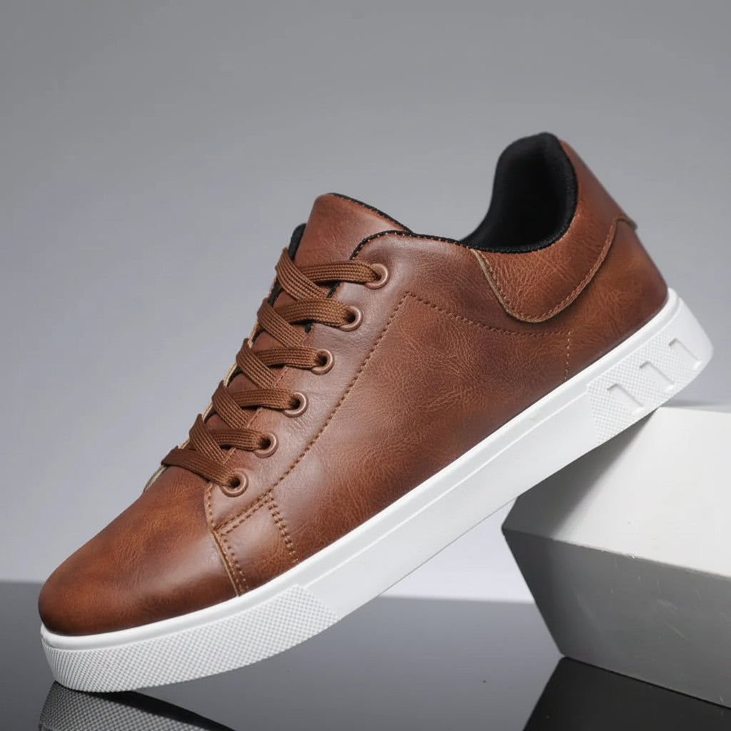 Brown leather sneaker with white sole on a reflective surface