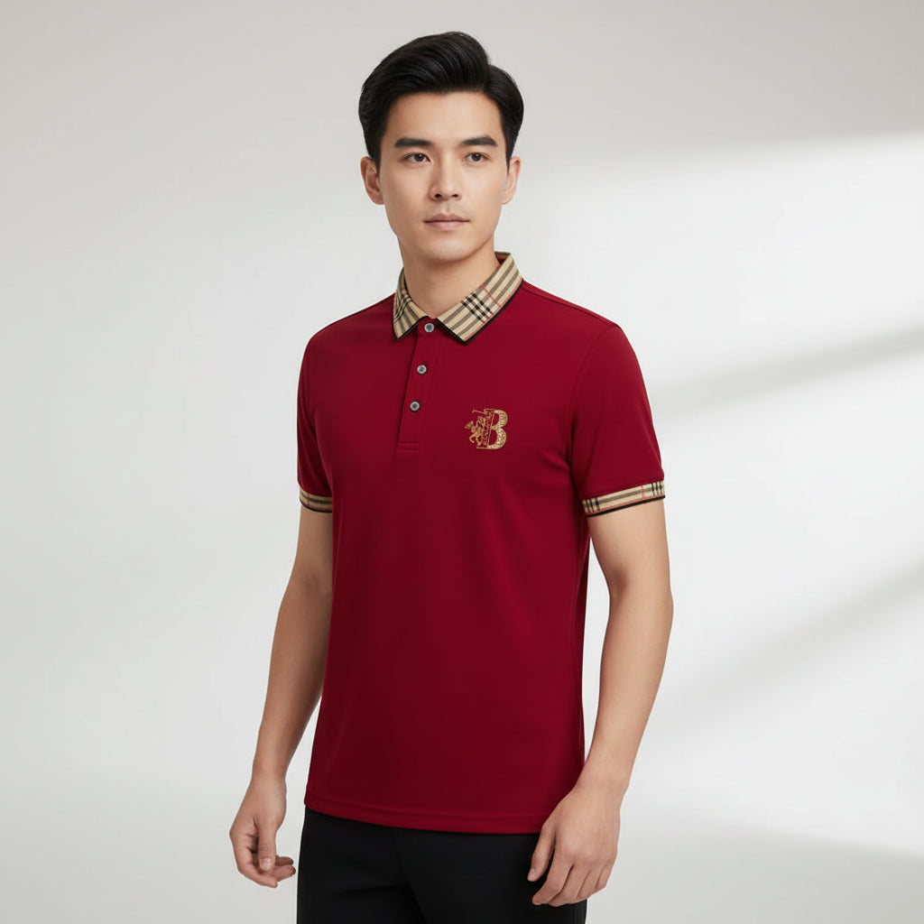 Red polo shirt with plaid collar and brand logo, accompanied by a watch on a gray surface.