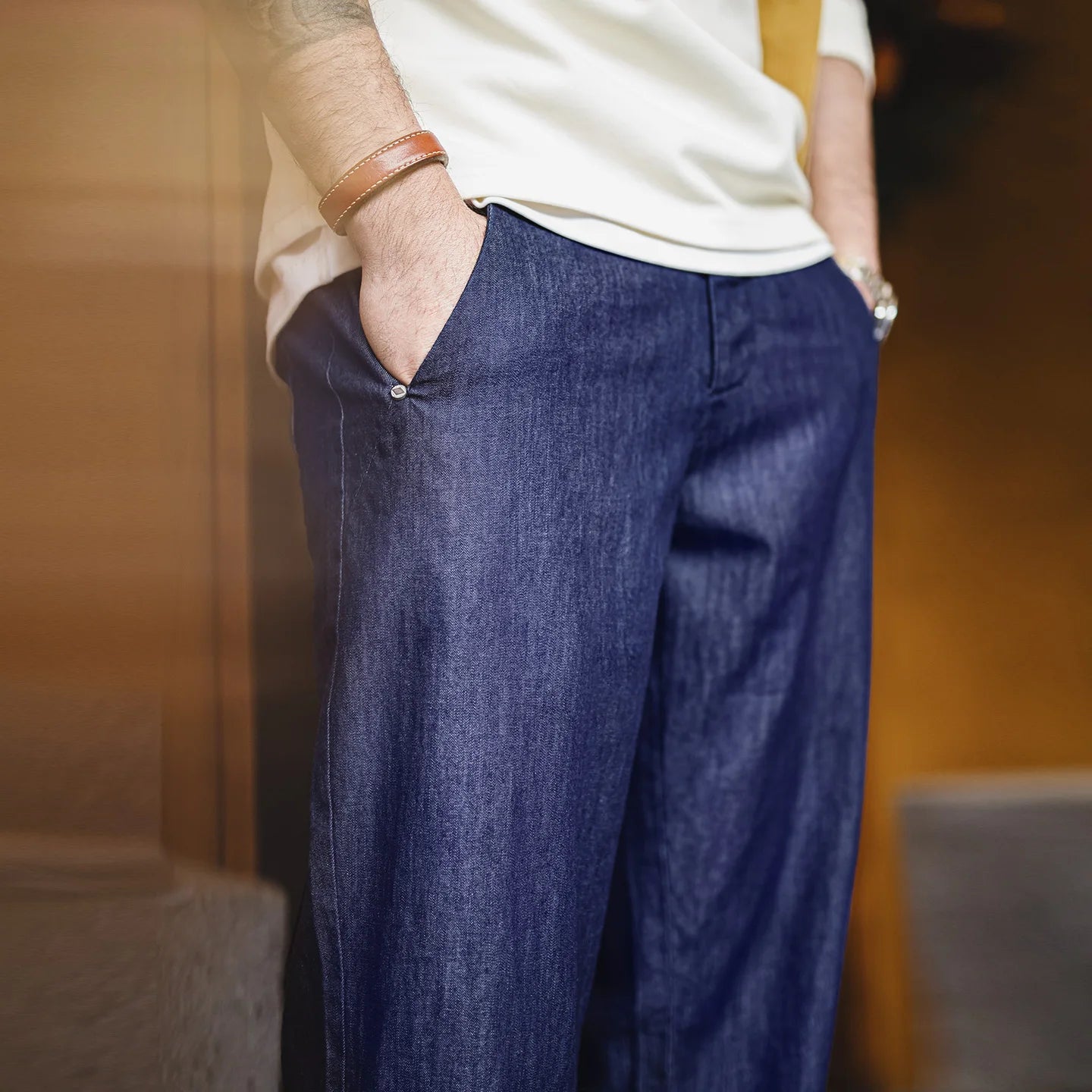 Person wearing blue pants and a white shirt with a blurred background