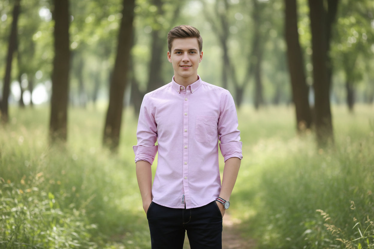 Person wearing a light purple button-up shirt with rolled-up sleeves against a blurred background
