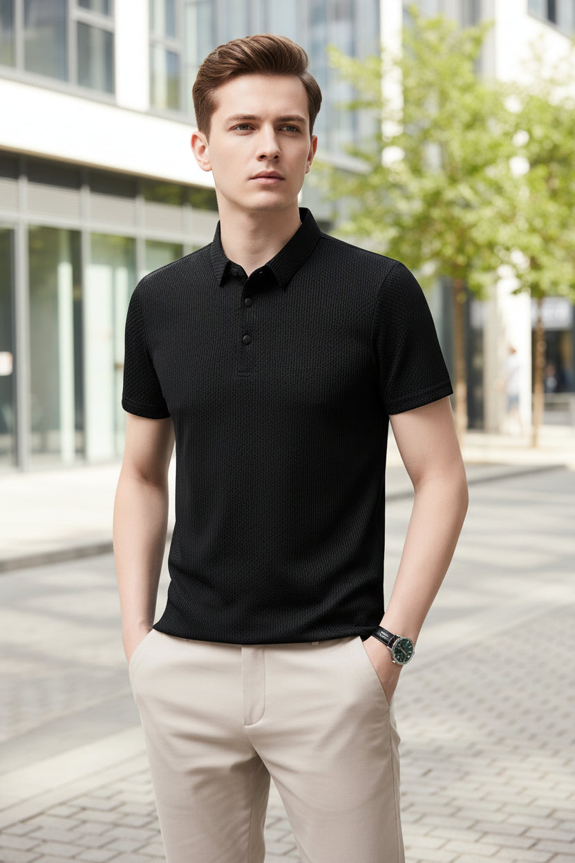 Person wearing a black textured polo shirt against a gray background