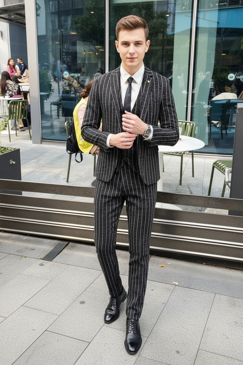 Person wearing a pinstripe suit standing in front of a glass door.