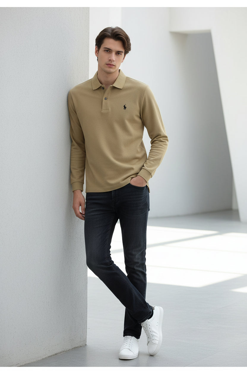 Beige polo shirt with a brand logo held by a hand, on a blurred background of books and shirts.